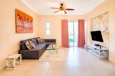a living room with a couch and a tv at Caribbean Treasure in Punta Cana