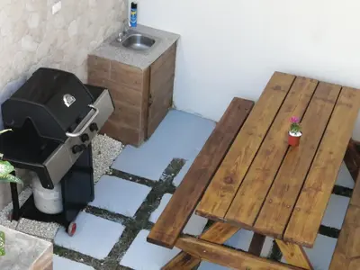 a room with a wooden table and a stove and a sink at Villa Laura Jarabacoa in Jarabacoa