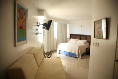 a hotel room with a bed and a couch at Aparta Hotel Plaza del Sol in Santo Domingo