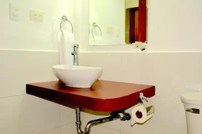 a bathroom with a bowl sink on a wooden counter at Aparta Hotel Plaza del Sol in Santo Domingo