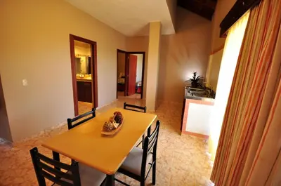 a dining room with a table and chairs and a kitchen at Hotel & Casino Flamboyan in Punta Cana