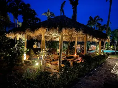 a gazebo with a straw roof at night at Hotel La Tortuga in Las Terrenas