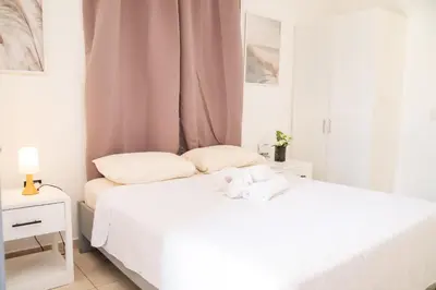 a white bedroom with two beds and a window at Hotel Casa Pierretta in Las Terrenas