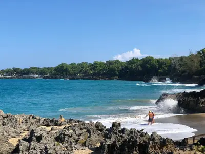 two people standing on a beach in the water at Vacations in the Caribbean Paradise in Sosúa