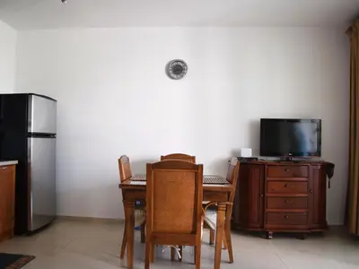 a dining room with a table and a tv and a refrigerator at Vacations in the Caribbean Paradise in Sosúa