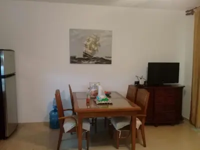 a dining room with a table and a tv at Vacations in the Caribbean Paradise in Sosúa