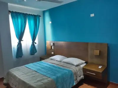 a blue room with a bed and a window at Figaro Hotel Samana in Santa Bárbara de Samaná
