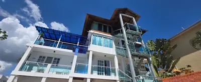 a tall white building with blue windows at Hotel Neptuno Refugio in Boca Chica