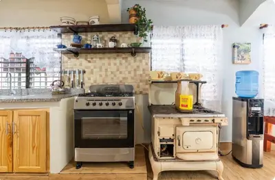 a kitchen with an old stove and a blender at Cabaña Don Tobo Jarabacoa RD in Jarabacoa