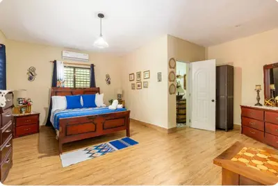 a bedroom with a bed with blue pillows at Cabaña Don Tobo Jarabacoa RD in Jarabacoa