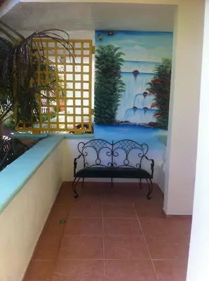 a bench in a room with a painting on the wall at Hotel Cambri in Nagua