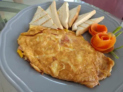 a blue plate with a omelet and chips and vegetables at Terraza Art Villa Dominicana in Punta Cana