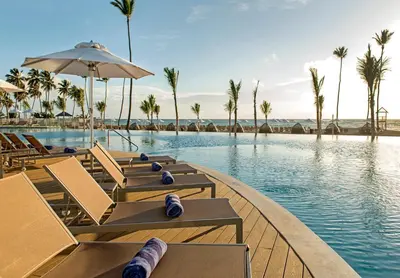 a pool at a resort with chairs and palm trees at Nickelodeon Hotels & Resorts Punta Cana - Gourmet All Inclusive by Karisma in Punta Cana