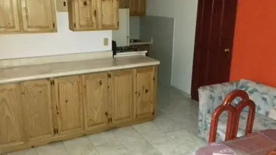 a kitchen with wooden cabinets and a counter top at Casa Picadilly in Boca Chica
