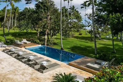 a swimming pool with lounge chairs and a resort at Wyndham Alltra Samana All Inclusive Resort in Las Galeras