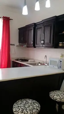 a kitchen with a counter with a sink and a microwave at Apartamento Frente Al Mar in San Felipe de Puerto Plata