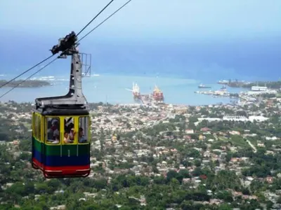 a cable car with people on it flying over a city at Apartamento Frente Al Mar in San Felipe de Puerto Plata
