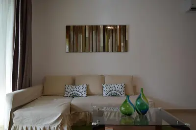 a living room with a couch and two vases on a table at Comfortable Apartment in Caribbean Paradise in Sosúa