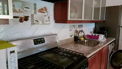 a kitchen with a stove top oven next to a sink at Comfortable Apartment in Caribbean Paradise in Sosúa