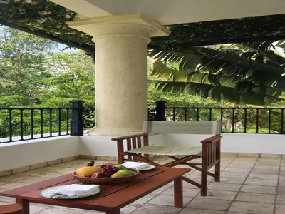 a table with a bowl of fruit on a balcony at Casa Colonial Beach & Spa in San Felipe de Puerto Plata