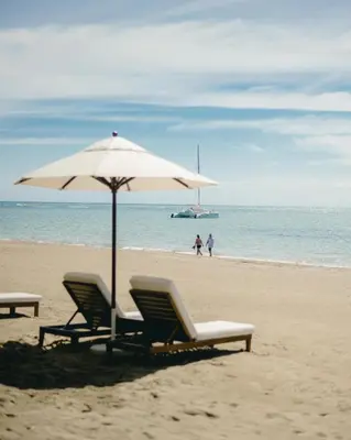 two chairs and an umbrella on the beach at Casa Colonial Beach & Spa in San Felipe de Puerto Plata