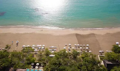 an aerial view of a beach with chairs and the ocean at Casa Colonial Beach & Spa in San Felipe de Puerto Plata