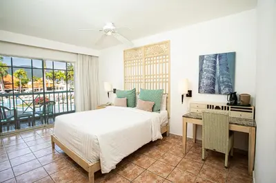a bedroom with a bed and a desk and a window at VH - Gran Ventana Beach Resort in San Felipe de Puerto Plata