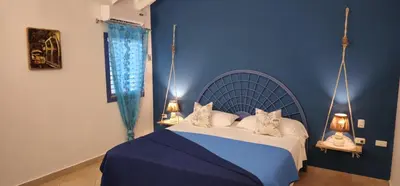 a blue bedroom with a bed with two cats on it at Casa Giò in Las Terrenas