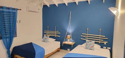 two beds in a room with a blue wall at Casa Giò in Las Terrenas