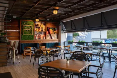a restaurant with tables and chairs in a room at Hotel Aladino in Santo Domingo
