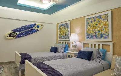a bedroom with two beds and a surfboard on the wall at Juan Dolio Costa del Sol in Juan Dolio