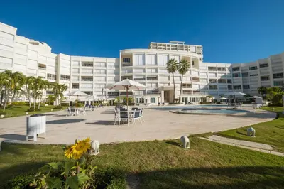 a large building with tables and chairs in front of it at Juan Dolio Costa del Sol in Juan Dolio