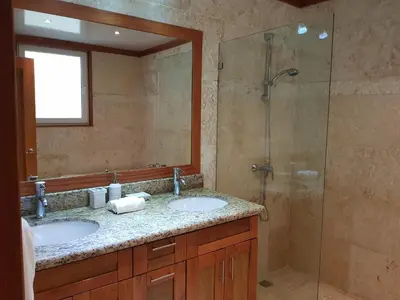 a bathroom with two sinks and a shower at Luxury Oceanview Condo 2 BR/2.5 BA in Sosúa