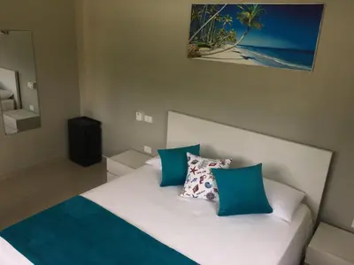 a bedroom with a bed with blue and white pillows at Residence Las Dos Palmas in Las Terrenas