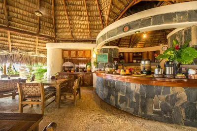 a restaurant with a bar and a table and chairs at Natura Cabana Boutique Hotel & SPA by Mint in Cabarete