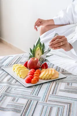 a plate of fruit and vegetables on a table at Hodelpa Centro Plaza in Santiago de los Caballeros