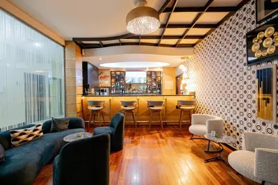 a living room with a couch and a bar at Hodelpa Garden Court in Santiago de los Caballeros
