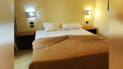 a bedroom with a bed with two pillows on it at Hotel Marimba Punta Cana in Punta Cana