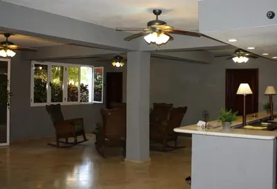 a living room with a ceiling fan and chairs at Hotel Marimba Punta Cana in Punta Cana