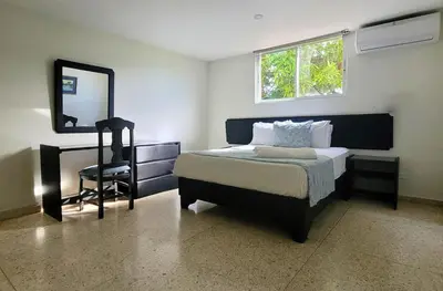 a bedroom with a bed and a mirror and a desk at Hotel Olimpo in La Romana