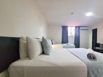 a bedroom with two beds and a window at Hotel Olimpo in La Romana