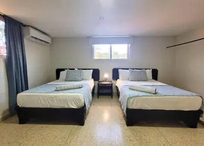 a bedroom with two beds and a window at Hotel Olimpo in La Romana