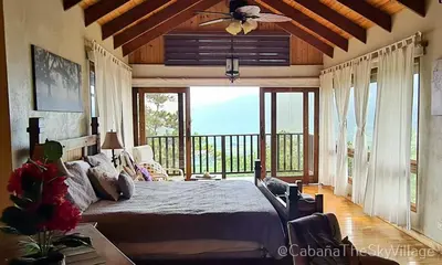 a bedroom with a bed and a ceiling fan at Villa The sky village in Jarabacoa