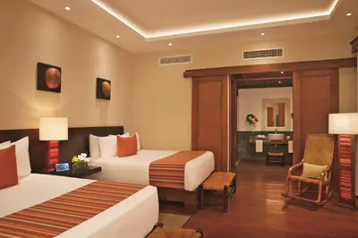 a hotel room with two beds and a desk at Zoetry Agua Punta Cana - All Inclusive in Punta Cana