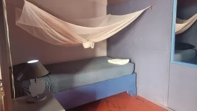 a bedroom with a bed with a mosquito net at Il Triangolo Hostel in Las Galeras