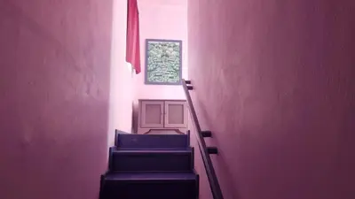 a hallway with purple walls and stairs with blue chairs at Il Triangolo Hostel in Las Galeras