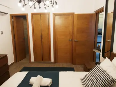 a bedroom with a bed and wooden cabinets at Central Park Tower in Santo Domingo