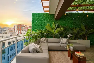 a balcony with a couch and a green wall at Central Park Tower in Santo Domingo