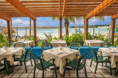 a restaurant with tables and chairs with the ocean in the background at Hotel whala!boca chica - All Inclusive in Boca Chica