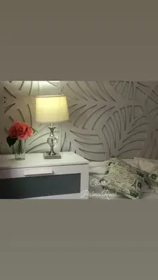 a bedroom with a bed with a table and a lamp at Oasis Palma Real santiago, Republica Dominicana in Santiago de los Caballeros
